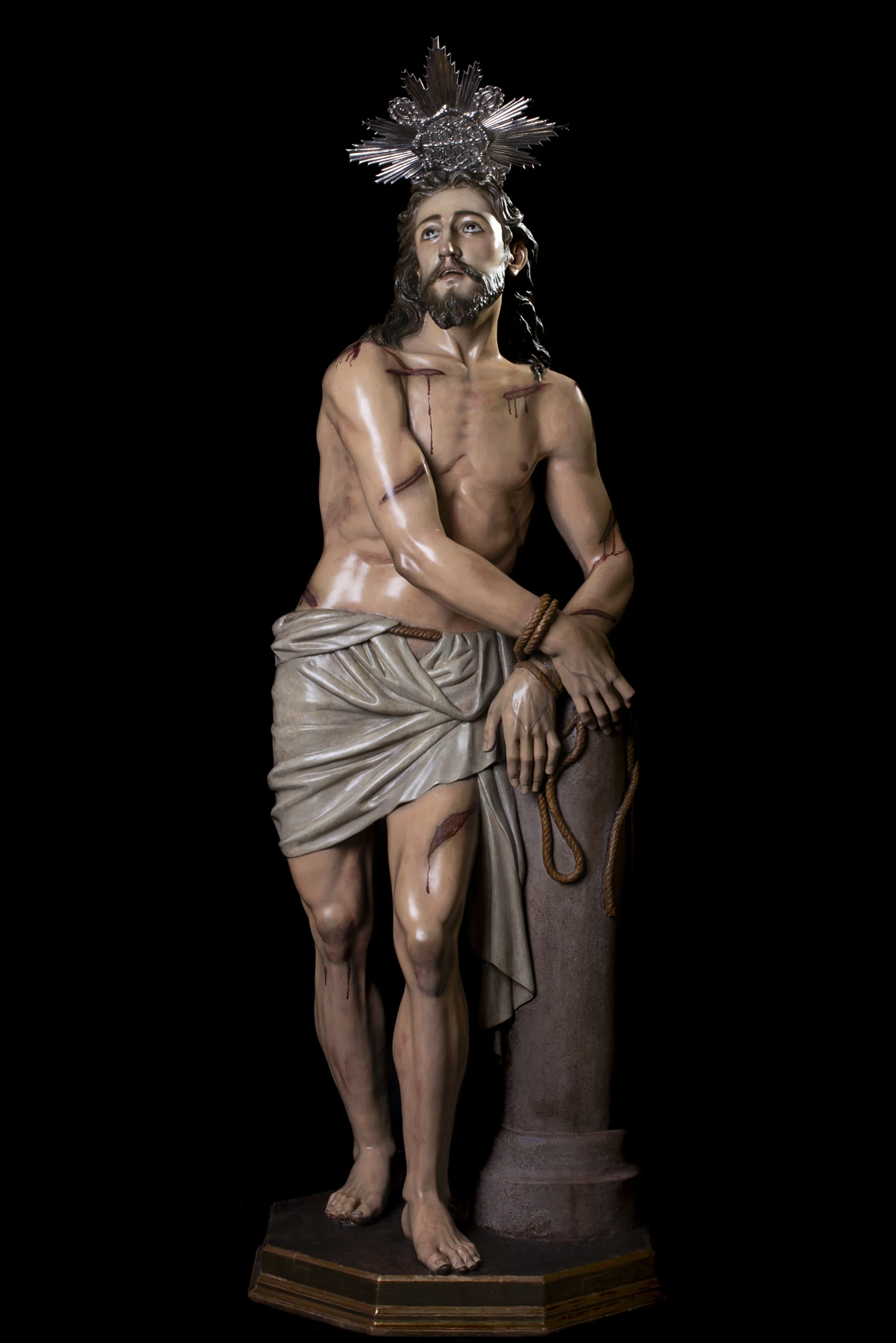 El Amarrado a la Columna de cuerpo entero, con la columna y la peana, sobre fondo negro